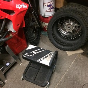 image showing Workshop roller stool recovered with Alpinestar leathers in a garage